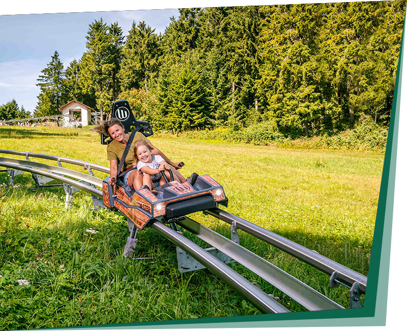 Mother and daughter riding downhill on a Mountain Coaster
